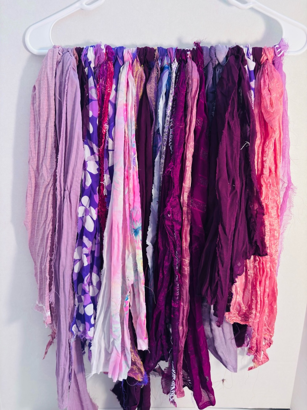 Vibrant sari silk fabric strands in purple and burgundy hues.